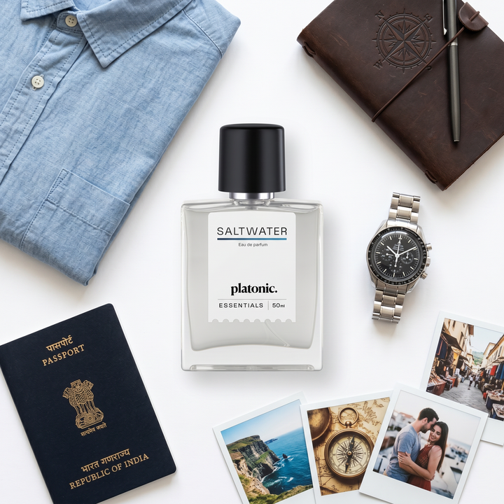 SALTWATER perfume travel flat lay with a passport, chambray shirt and watch